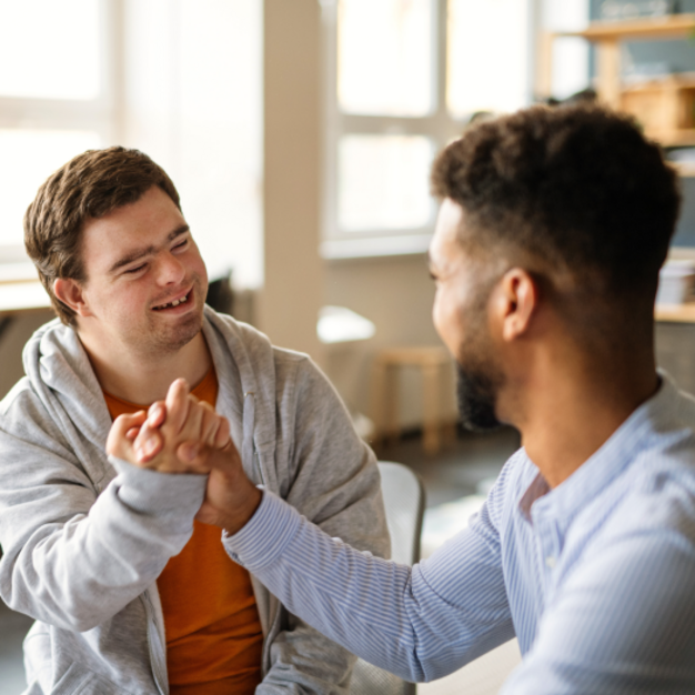 Zwei Personen geben sich zur Begrüßung die Hand