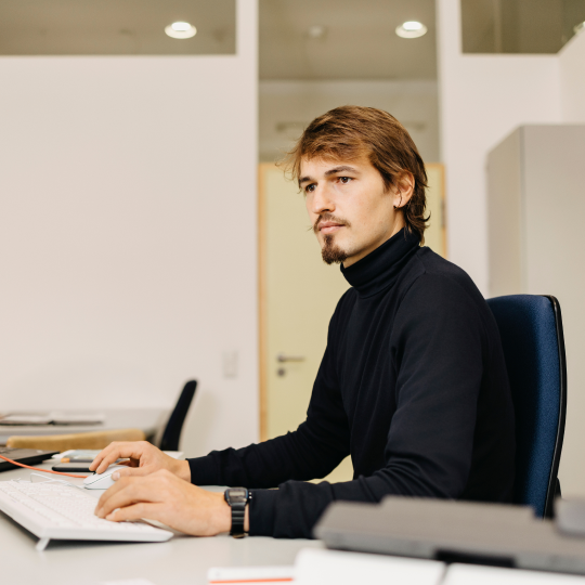 Mitarbeiter arbeitet am Schreibtisch im Büro